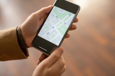 Çağdaş, bej ceketli, trençkotlu ve elinde akıllı telefon tutan genç iş adamının elleri.
