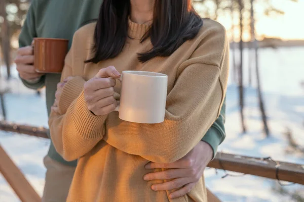 Joven Hombre Cariñoso Abrazando Esposa Con Taza Caliente Mientras Ambos — Foto de Stock