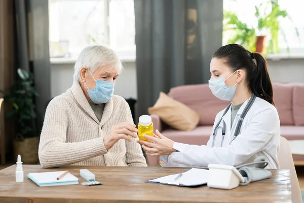 Ung Kvinnlig Läkare Whitecoat Och Skyddsmask Hålla Flaska Piller Över — Stockfoto