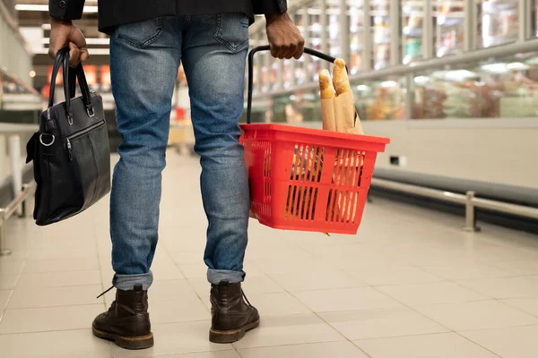 若い男の低セクションの背面ビューとともに赤いバスケット現代的なスーパーマーケットで冷凍食品と大と長いディスプレイの間を移動 — ストック写真