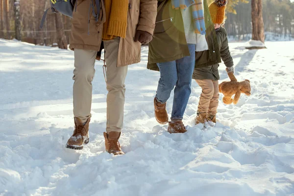母亲和小女儿穿着温暖的冬衣 在去乡间住宅的路上玩雪地漂流 父亲走在他们前面 — 图库照片