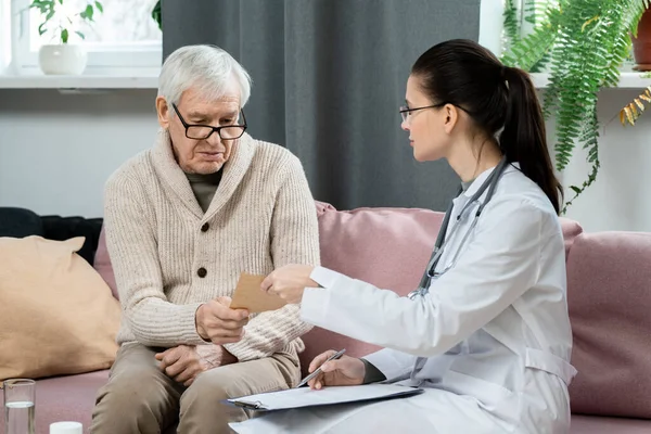 Junge Brünette Allgemeinmedizinerin Zeigt Kranken Senioren Papier Mit Ihren Medizinischen — Stockfoto
