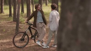 Tam PAN pozu. Kafkasyalı birkaç yavaş arkadaş ormanda dikilip bisiklet sürdükten sonra sohbet ediyorlar.