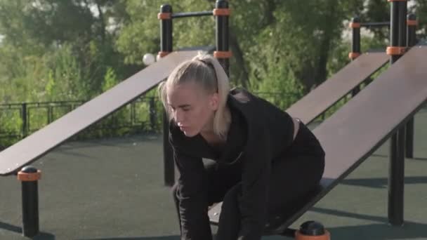 Odchylne Ujęcie Młodej Atrakcyjnej Sportowca Siedzącej Latem Urządzeniach Fitness Boisku — Wideo stockowe