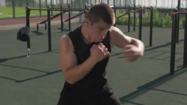 Spor sahasında boks antrenmanı yapan konsantre genç sporcunun el kamerası görüntüsü.