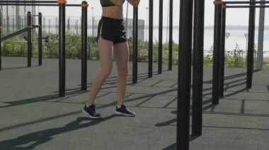 Spor sahasında tek başına boks antrenmanı yapan genç bayan boksörün tam yan görüntüsü.