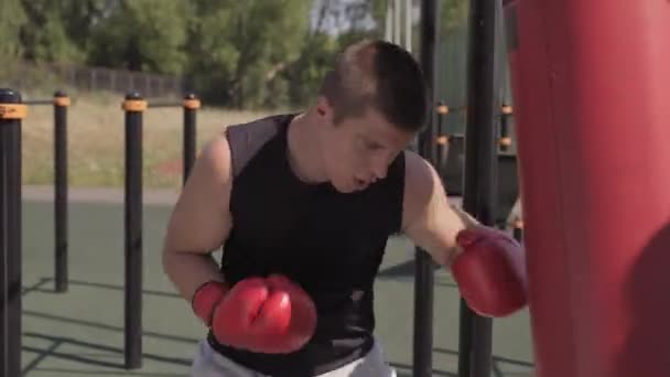 Medelhög Bild Ung Kaukasisk Idrottsman Boxning Boxningssäck Idrottsplats Utomhus Sedan — Stockvideo
