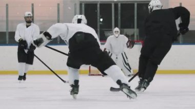 Dikiz aynasından tam görüş, yavaş yavaş konsantre olan hokey kalecisi ağlarını korurken forvet oyuncuları puck 'a saldırıyor.
