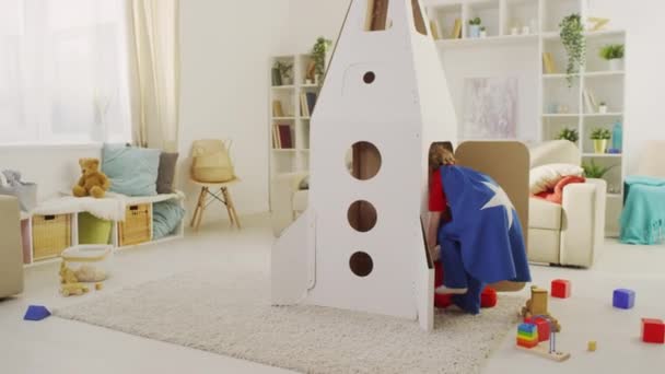 Full Shot Niños Trajes Superhéroe Entrar Casa Cohete Juguete Mirando — Vídeo de stock