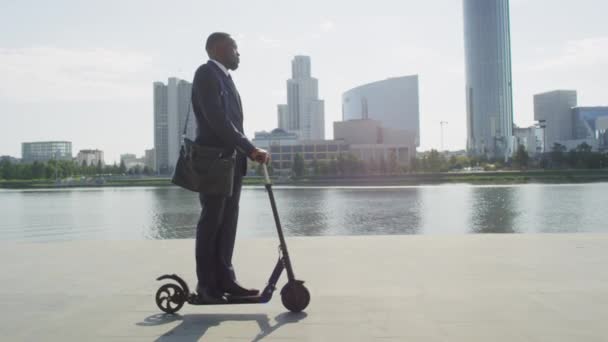 Vista Lateral Cámara Lenta Hombre Negocios Afroamericano Montado Scooter Eléctrico — Vídeos de Stock