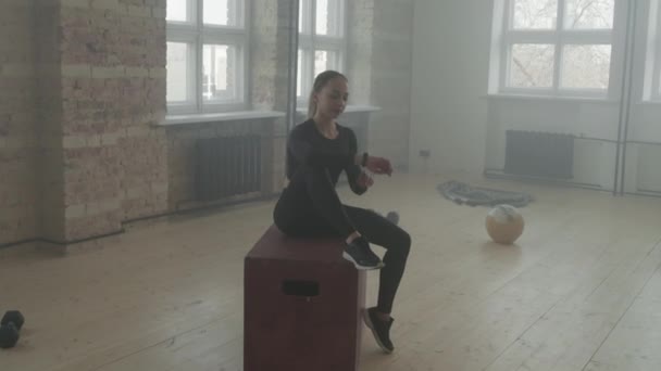 Πλήρης Εικόνα Νεαρής Γυμναστικής Γυναίκας Που Κάθεται Αθλητικό Εξοπλισμό Εσωτερικούς — Αρχείο Βίντεο