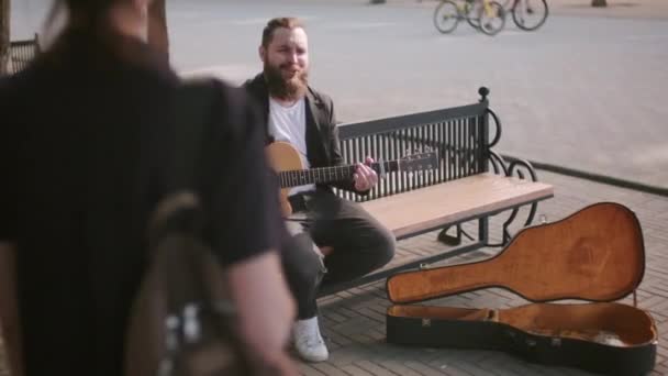 Tracking Shot Van Vrolijke Bebaarde Mannelijke Straatmuzikant Zittend Een Bankje — Stockvideo