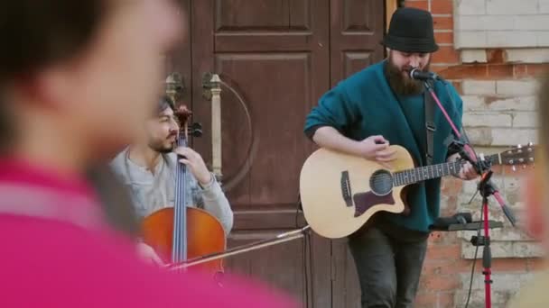 外で群衆のための歌を演奏しながら チェロとアコースティックギターを演奏ストリートミュージシャンの中ショット — ストック動画