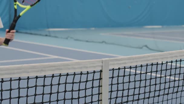2名女子在网球赛中互相竞争的慢动作中等特写 在室内比赛前走近网球网的不同侧面 互相握手 — 图库视频影像