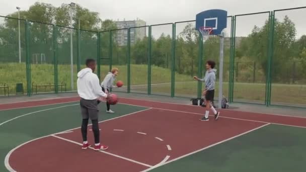 Tracking Shot Van Drie Jonge Mannen Sportkleding Opwarmen Basketballen Het — Stockvideo
