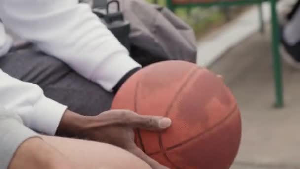Ruční Zblízka Záběr Nepoznatelný Černoch Rotující Basketbal Rukou Sedí Přítelem — Stock video
