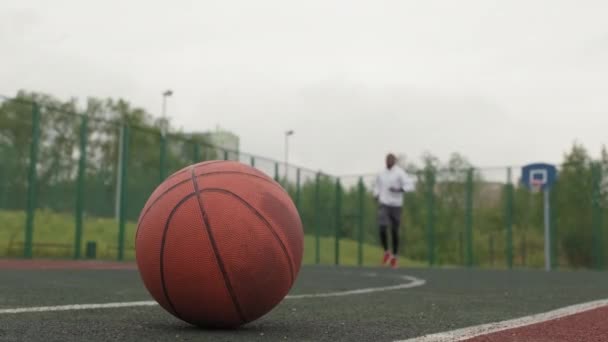 Закрытый Выстрел Фокусом Мяч Лежащий Земле Открытой Баскетбольной Площадке Чёрный — стоковое видео