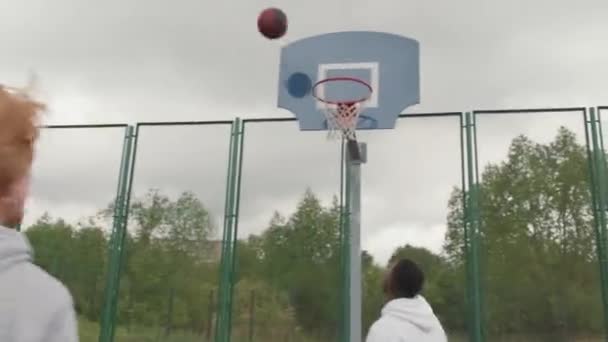 Tiro Rastreo Mano Grupo Amigos Varones Con Capuchas Jugando Streetball — Vídeo de stock