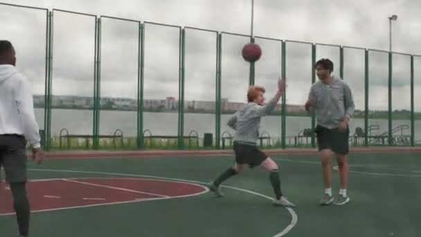 Handheld Tracking Shot Van Vier Jonge Mannen Spelen Streetball Samen — Stockvideo