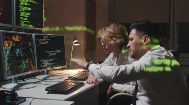 Yandan bakıldığında, modern olgun erkek ve genç kadının bilgi güvenlik sistemindeki sorunları analiz ederken çekilmiş görüntüleri görülüyor.