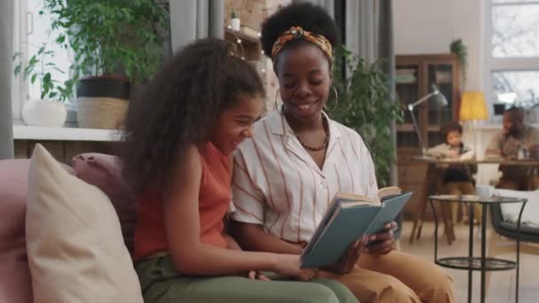 Medium Pan Shot Cheerful Afro American Mom Daughter Reading Book — Stock Video