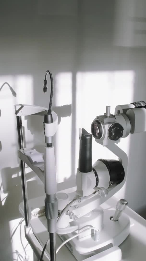現代のプロのフォターマシンの人々と垂直ショット日光の下で眼科事務所で目の検査のための — ストック動画