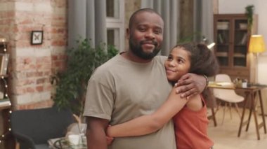 Orta boy PAN portresi. 10 yaşında, neşeli, Afro-Amerikan bir kız. Babası kameraya gülümsüyor.