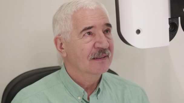 Pas Záběr Kavkazského Staršího Muže Sedícího Židli Kanceláři Očního Lékaře — Stock video