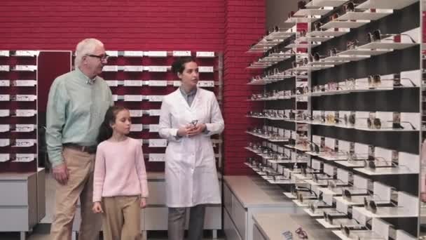 Medium Shot Female Optician White Gown Showing Selection Eyeglasses Shelves — Stock Video