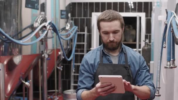 Dijital Tabletli Erkek Bira Fabrikası Işçisinin Bira Üretim Fabrikasında Yürüdüğü — Stok video