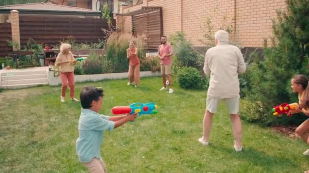 在阳光明媚的日子里 六代多代快乐的一家人在户外玩水枪 慢动作全速前进 — 图库视频影像