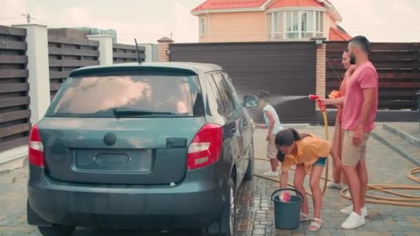 Sıcak Yaz Gününde Dört Kişilik Mutlu Modern Aile Arabalarını Yıkıyorlar — Stok video