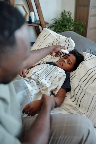 Jovem Homem Africano Segurando Termômetro Pela Testa Seu Filho Doente — Fotografia de Stock