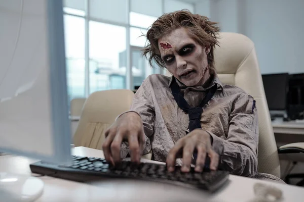 Straszny Biznesmen Malowaniem Ciała Zombie Patrząc Ekran Komputera Naciskając Klawisze — Zdjęcie stockowe