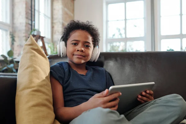 Ευτυχισμένο Μικρό Αγόρι Ακουστικά Και Tablet Κοιτάζοντας Σας Ενώ Κάθεται — Φωτογραφία Αρχείου