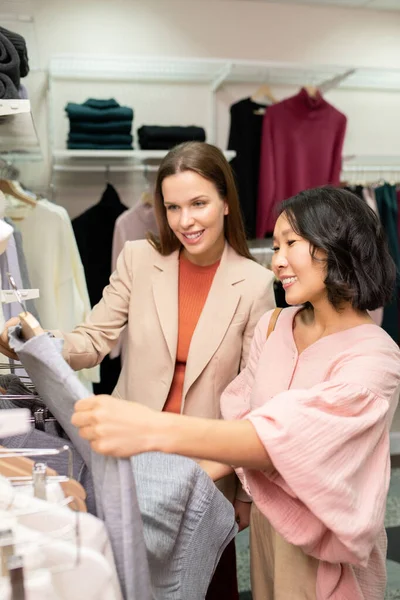 Mladá Usměvavá Prodavačka Pomáhá Zákazníkovi Naštípat Správné Šaty Obchodě Oblečením — Stock fotografie