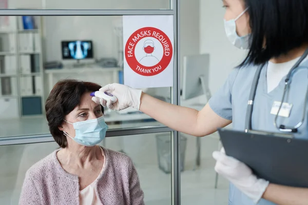 Handskar Ung Kvinnlig Läkare Eller Sjuksköterska Enhetlig Mätning Kroppstemperatur Hos — Stockfoto