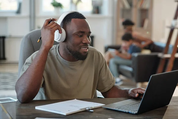 Glimlachende Jonge Afrikaanse Man Koptelefoon Zit Aan Tafel Voor Laptop — Stockfoto