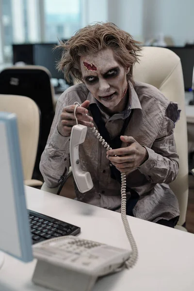 Mladý Podnikatel Zombie Tělo Drží Telefon Přijímač Zatímco Sedí Stolu — Stock fotografie