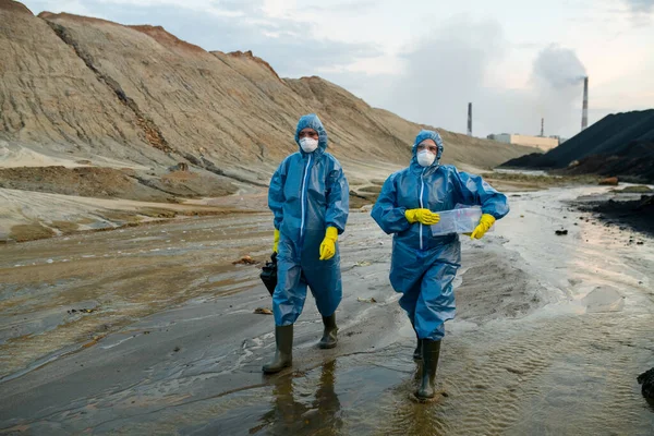 Duas Jovens Cientistas Contemporâneas Macacões Protetores Azuis Botas Borracha Descendo — Fotografia de Stock