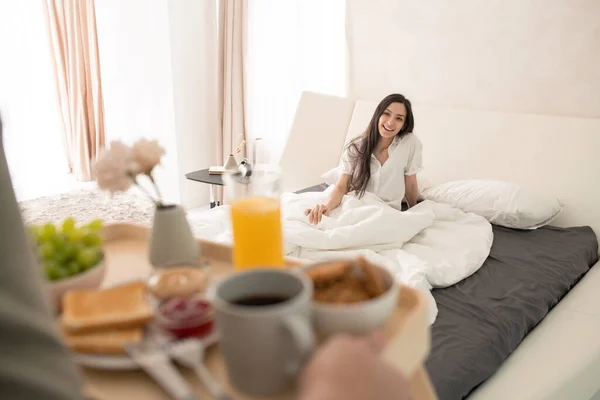 Glückliche Junge Brünette Frau Sitzt Unter Einer Weißen Decke Auf — Stockfoto