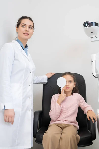 Cute Little Girl Casualwear Doing Eye Test Nowoczesnych Klinikach Okulistycznych — Zdjęcie stockowe