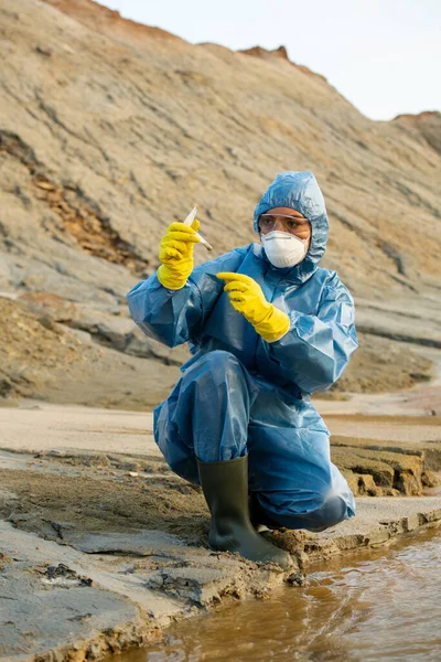 Ecolóloga Guantes Monos Respirador Anteojos Mirando Frasco Con Muestra Agua —  Fotos de Stock