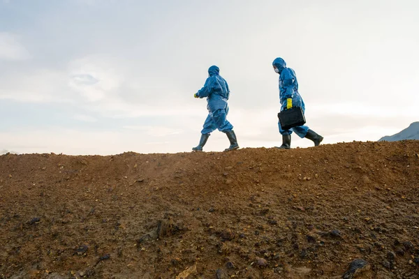 Боковой Обзор Двух Исследователей Защитном Комбинезоне Движущихся Вершине Холма Грязной — стоковое фото