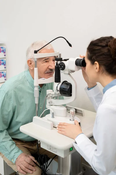 Mladá Brunetka Žena Oftalmolog Whitecoat Testování Zraku Seniora Mužského Pacienta — Stock fotografie