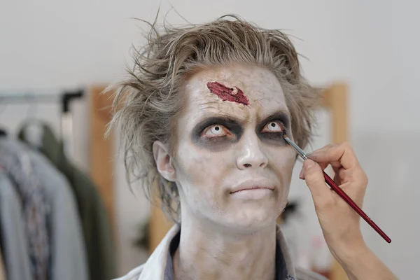 Ręka Makijażystki Pędzlem Malowania Zombie Podoku Młodego Biznesmena Lub Aktora — Zdjęcie stockowe