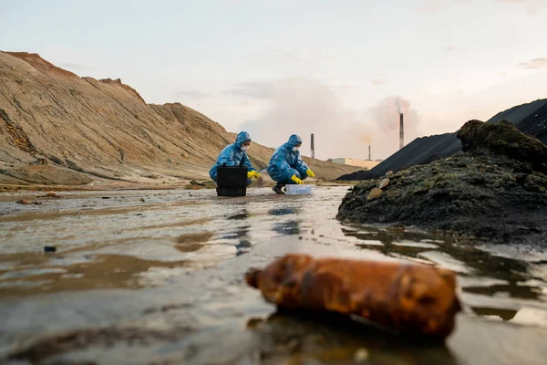 两名身穿橡胶手套 防护服 眼镜和呼吸器的生态学家研究危险地区有毒水的特性 — 图库照片