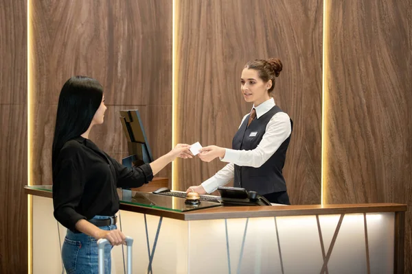 Joven Recepcionista Morena Uniforme Pie Lugar Trabajo Pasando Tarjeta Plástico —  Fotos de Stock