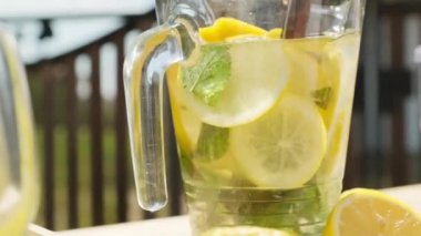 Yaz günü açık havada cam sürahide limonata karıştırmayı unutma. Nane ve limonlu ev yapımı limonata.