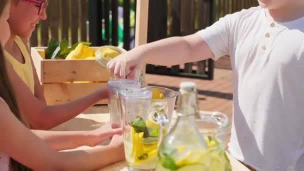 10歳の男の子の中出し熱い夏の日にさわやかな飲み物を販売しているスマート女の子によって作られた汚いスタンドからレモネードを購入 — ストック動画